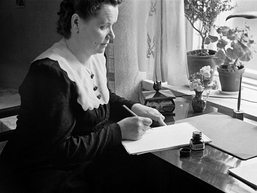 Nainen kirjoittaa pöydän ääressä mustekynällä, 1940-luku. Kuva:<span class="photographer">Väinö Kannisto / Helsingin kaupunginmuseo</span>
