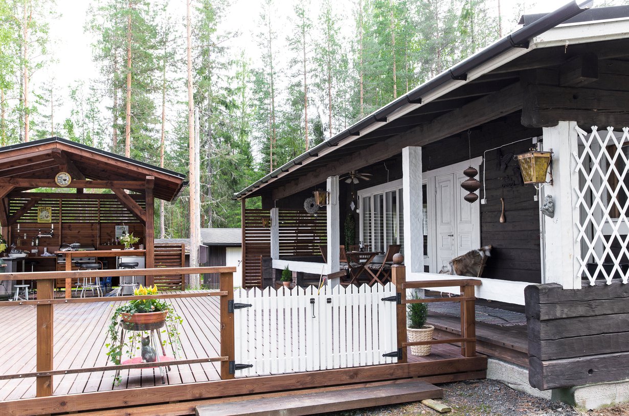 Suojaisella kuistilla kahvitellaan aamuin illoin. Terassi on Arjan lempipaikka mökillä. Kesäkeittiö on Raimon valtakuntaa.