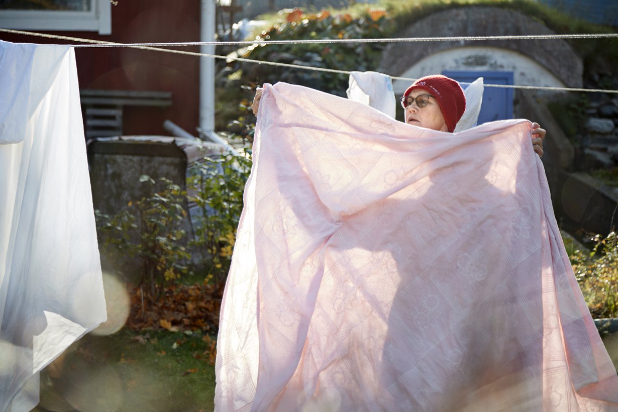Utölainen Hanna Kovanen ripustaa pyykkiä kotinsa pihalla.