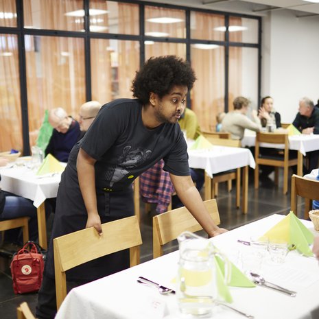 Se on katettu. Alppilan kirkon määräaikainen työntekijä Mohamed Muhamed Ahmed viimeistelee Alppilan kirkon lauantaibrunssin kattausta. 