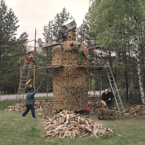 Pekka Turunen ja rakennuskumppanit ahkeroivat vodkapullonm muotoisen pinon parissa.