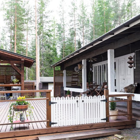 Suojaisella kuistilla kahvitellaan aamuin illoin. Terassi on Arjan lempipaikka mökillä. Kesäkeittiö on Raimon valtakuntaa.