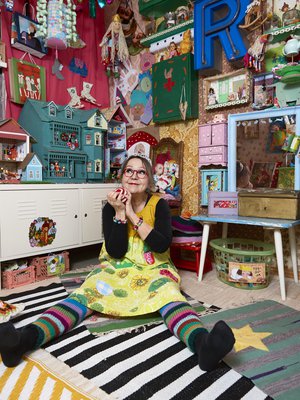 Riitalla ja hänen puolisollaan Veikolla on kuusi lasta ja kymmenen lastenlasta. – Tämä huone on varattu pienille. Kaikkeen saa koskea, ja mummi saa leikkiä mukana. Monitaskuinen mekkoni on tehty retrolakanasta.