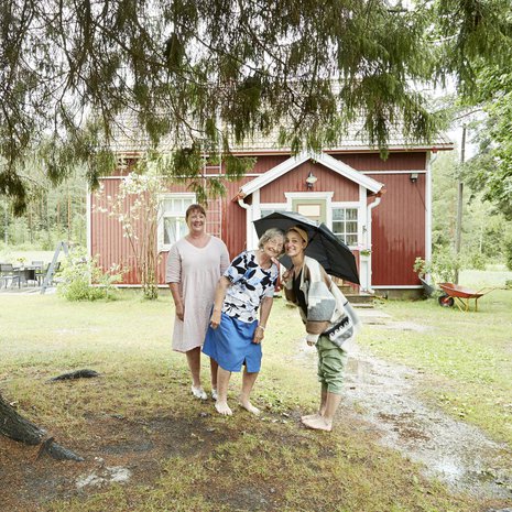 Sari Laakso (vas.), Eliisa Skrifvars ja Krista Laakso pitävät kesäsadetta pihakuusen alla.