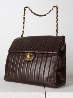 Merkkilaukut ovat suosittuja muoti-&vintage-huutokaupoissa. Tämä Chanelin nahkalaukku kooltaan 37x13x31 cm maksoi huutomaksuineen Bukowskin muotihuutokaupassa Tukholmassa keväällä runsaat tuhat euroa. Laukussa on hieman kulumia nurkissa.