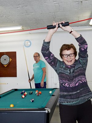 Malla Kuusisaari vahvistaa vatsa-lihaksiaan senioritalon kuntosalilla. Pekka Kuusisaari ja Veikko Muurinen ottavat  biljardimatsin.