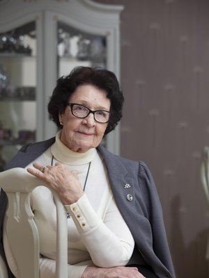 Salme Hentula kantaa ylpeänä Sotaorpomerkkiä ja Kaatuneitten omaisten liiton hopeista ansiomerkkiä.