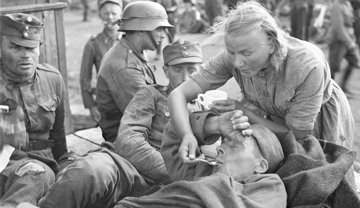 Kiestinki-Tuoppajärvi 15.8.1941. Nuori rintamalotta helpottaa haavoittuneen oloa.