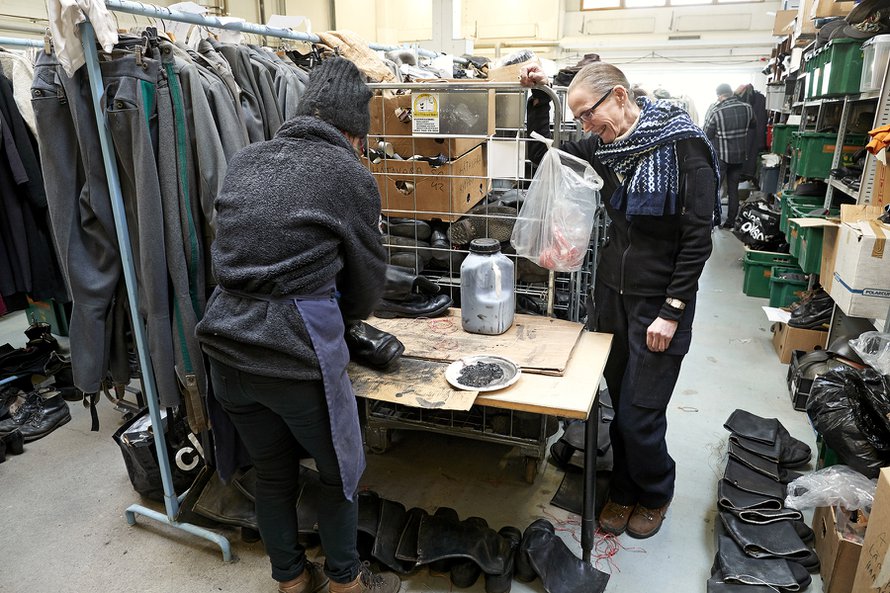 Marjatta Nissinen seuraa, kuinka kenkäsuunnittelija Hanna Kainulainen huoltaa saappaita.
