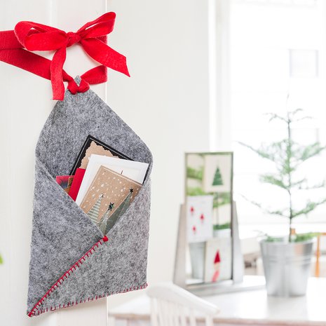 Korttitasku taitetaan huopakolmiosta. Tikkaukset ommellaan käsin napinläpipistoin.