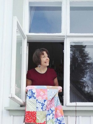 Riikka Kangasmäki kotinsa ikkunassa.