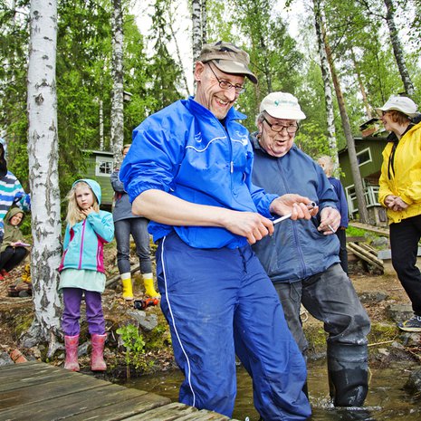 Otava Mäkinen, 14, ja Iben Madsen, 7,  oppivat tulevaa varten. Jukka Virtanen (edessä) ja Lauri Salonen asentavat laituria, Irma Salonen seuraa. 