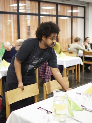 Se on katettu. Alppilan kirkon määräaikainen työntekijä Mohamed Muhamed Ahmed viimeistelee Alppilan kirkon lauantaibrunssin kattausta. 