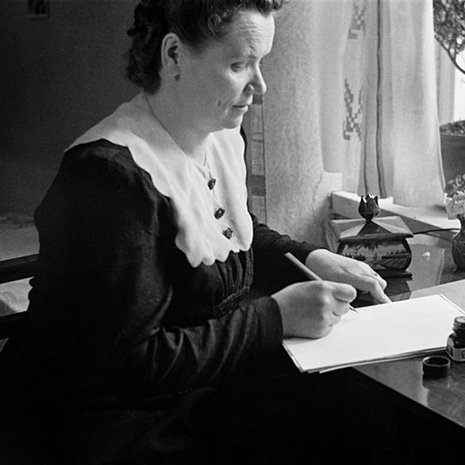 Nainen kirjoittaa pöydän ääressä mustekynällä, 1940-luku. Kuva:Väinö Kannisto / Helsingin kaupunginmuseo