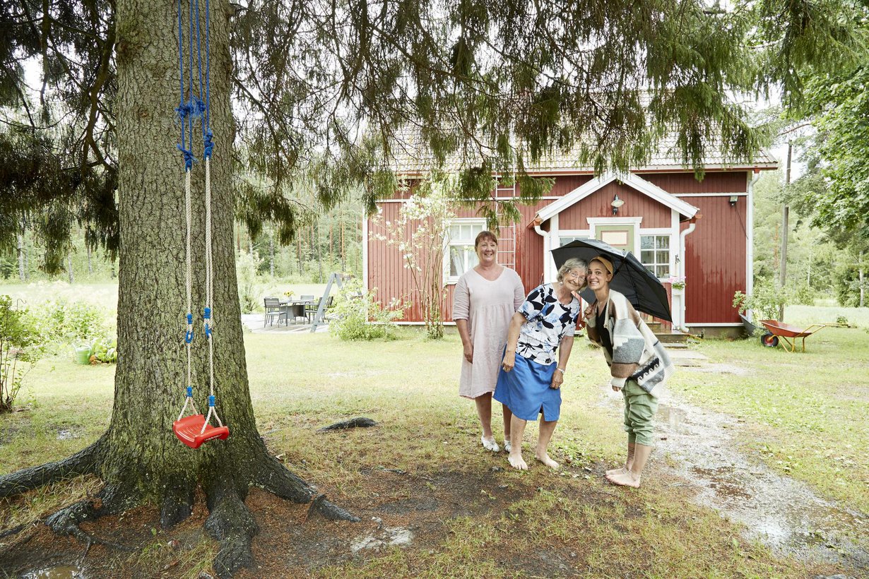 Sari Laakso (vas.), Eliisa Skrifvars ja Krista Laakso pitävät kesäsadetta pihakuusen alla.