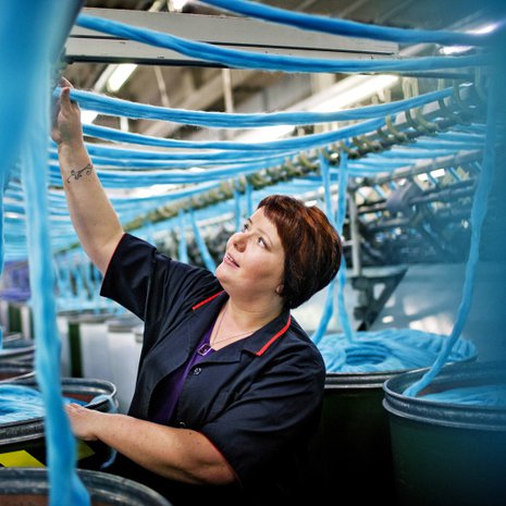 Kirsti Tuviala on viihtynyt talossa yli 20 vuotta. H&auml;n on joka paikan h&ouml;yl&auml;, mutta suosikki on kehruukone. T&ouml;it&auml; paiskitaan kahdessa vuorossa klo 6&ndash;14 ja 14&ndash;22. Tuotannossa on 80 ihmist&auml;.&ndash; Aikanani on tullut paljon uusia koneita ja langat ovat tulleet v&auml;rikk&auml;&auml;mmiksi, Kirsti kertoo.