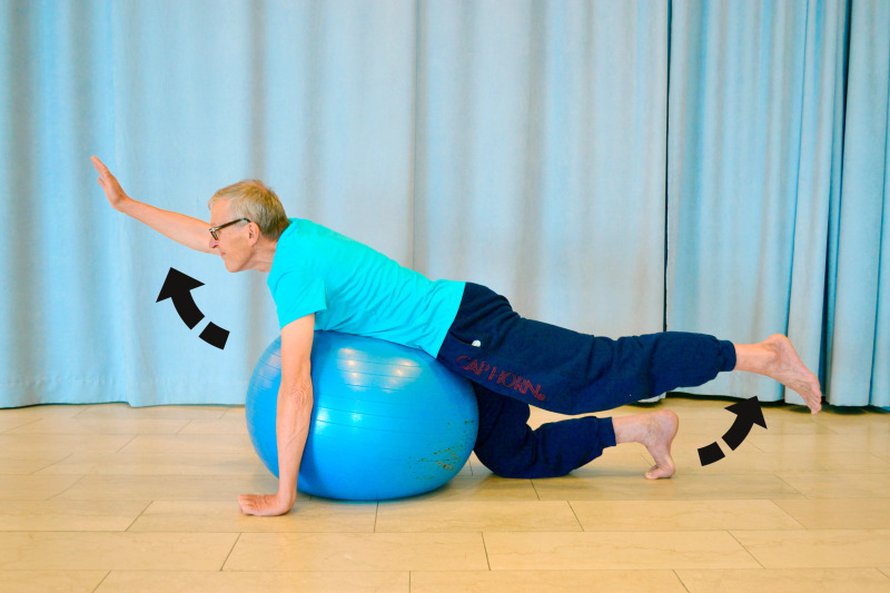 KUORMITA SELKÄÄ. Asetu vatsallesi pallon päälle. Aseta toisen jalan polvi tai varpaat lattiaan tasapainosi takeeksi ja pidä tarvittaessa vastakkaisen käden kämmen tai sormet lattiassa. Ojentele samaan aikaan toista jalkaa ja sen vastakkaista kättä reiluun kohoasentoon ja pidä asento hetken ajan. Laske alas. Tee noin viisi kertaa tai niin kauan, että liike tuntuu selkälihaksissa ja reiden takaosassa. Tee liike seuraavaksi vastakkaisella kädellä ja jalalla.